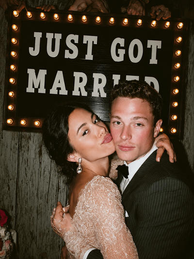 Newlyweds posing under a Just Got Married sign